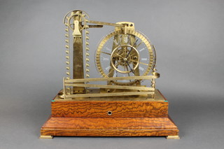 A Congreves style mantel clock in the form of a wheel with rolling balls and having a fusee movement, raised on an oak base 16"h x 17"w x 9"d 