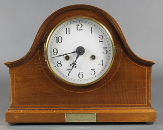 An 8 day striking mantel clock with enamelled dial and Arabic numerals contained in an arched inlaid mahogany case 