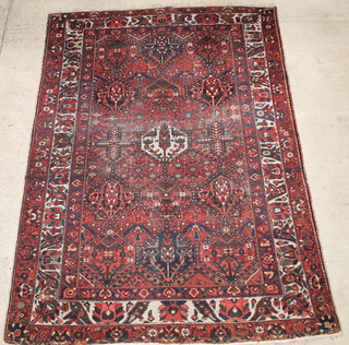 A Persian Bakhtiari red ground rug 113" x 82 1/2", in wear 