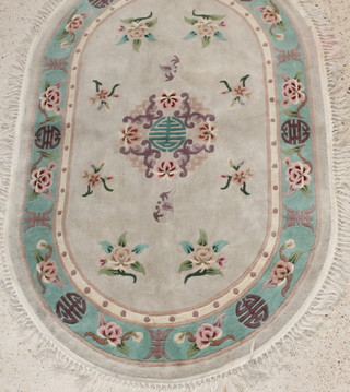A white and green ground oval floral patterned Chinese rug 24" x 49" 
