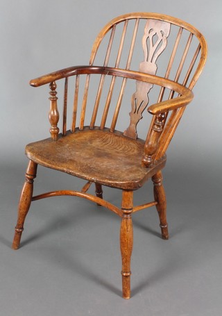 A 19th Century oak and elm stickback armchair with crinoline stretcher, raised on turned legs 