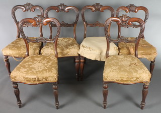 A set of 6 mid Victorian mahogany balloon back dining chairs with fleur de lis crest and centre scroll rail, with serpentine seats on octagonal baluster legs 