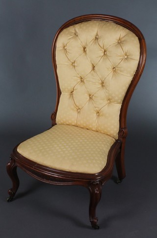 A Victorian mahogany show frame nursing chair upholstered in yellow Dralon, raised on cabriole supports