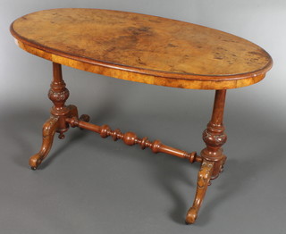 A mid Victorian oval walnut centre table, the quarter veneered top raised on turned and carved baluster supports and scroll feet with a turned centre stretcher 27"h x 44"w x 24"d 