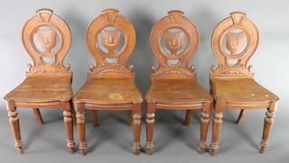 A set of 4 Victorian oak open back hall chairs with painted armorial and serpentine seat, raised on tapered legs