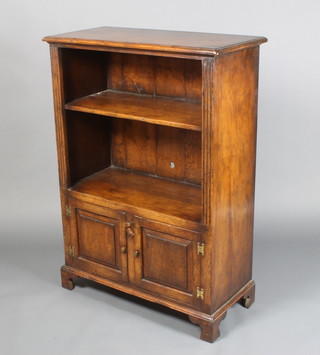 An "Ipswich oak" bookcase, the upper section fitted a shelf with columns to the side above a cupboard enclosed by a panelled door 48"h x 34"w x 16"d 