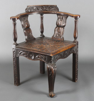 A Georgian carved oak corner chair with acanthus top rail and vase splat with solid seat, raised on cabriole legs 