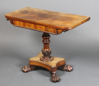 A William IV mahogany and rosewood swivel top tea table with moulded decoration, raised on carved turned stem with quatrefoil base and claw feet 28"h x 35 1/2"w x 17 1/2"d