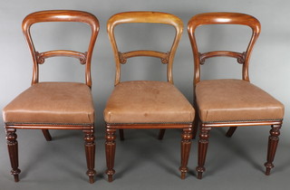 A set of 3 Victorian mahogany bar back dining chairs with carved mid rails and over stuffed seats, raised on turned and reeded supports 
