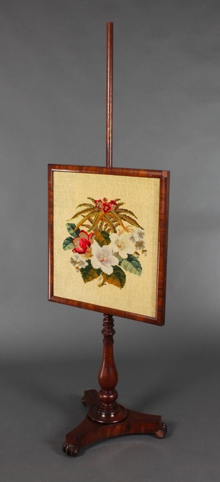An early Victorian mahogany pole screen with square wool work banner, raised on a triform base with scroll feet 