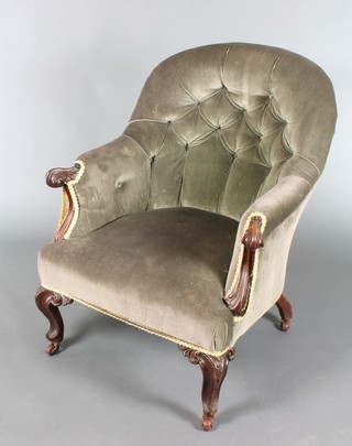 A Victorian carved mahogany show frame armchair upholstered in grey corduroy material, raised on cabriole supports 