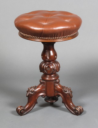 A Victorian carved mahogany revolving adjustable piano stool with brown buttoned back leather seat