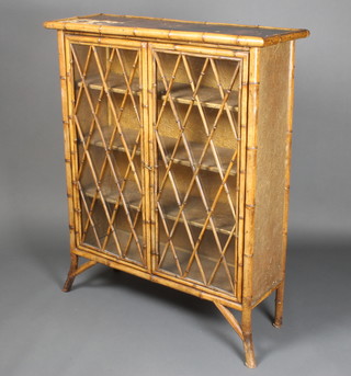 An Edwardian bamboo display cabinet enclosed by glazed and bamboo decorated doors, raised on splayed feet 45"h x 37"w x 13"d 