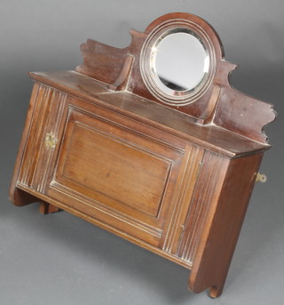 An Edwardian walnut hanging cabinet, the raised back fitted a circular bevelled plate mirror enclosed by a panelled door 20"h x 20"w x 7"d 