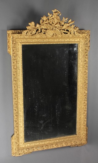 A 19th Century rectangular French plate mirror contained in a decorative gilt frame, surmounted by a basket of flowers etc 51"h x 31"w 