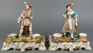 A pair of 19th Century Continental porcelain ink stands in the form of standing soldier and lady with pen holders, ink wells and sand shakers on rococo bases 8" 