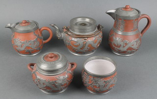 A pewter mounted tanware part teaset comprising tea kettle, hot water jug, sugar bowl and slop bowl decorated with dragons, with impressed marks 