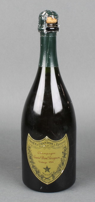 A bottle of 1964 Moet & Chandon Dom Perignon champagne (slight damage to green paper wrapper) 