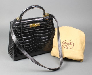 Hermes, a lady's black leather "Kelly" handbag, stamped to the inside Hermes Paris, Made in France, with lock, key and possible replacement shoulder strap, complete with original Hermes dust bag 8 1/4" high x 11 1/4" wide 