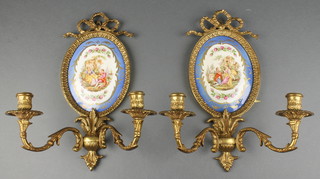 A pair of reproduction porcelain and gilt metal twin light sconces decorated romantic scenes (1 cracked) 