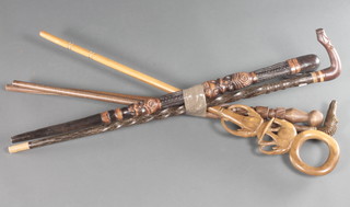 A Maori style stick together with 4 other carved wooden walking sticks