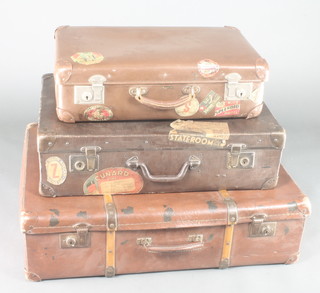A brown fibre suitcase 8"h x 30"w x 23"d with Union Castle label, a brown fibre suitcase 7"h x 26"w x 17"d with Cunard Line label, South African Line label, Sydney label, an Antler brown fibre suitcase 6"h x 22" x 14" with Hotel New Yorker label and other lables
 
