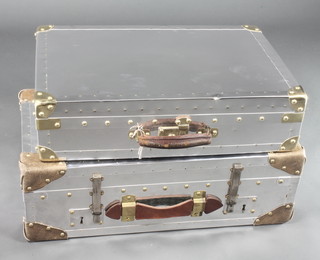A polished steel and brass finished stage prop sealed suitcase 6"h x 24"w x 15"d and 1 other 8 1/2"h x 26"w x 14 1/2"d
