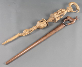A carved oak stick decorated a viper and various drumming figures and 1 other the handle in the form of an antelope (f and r) 