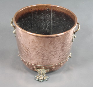 A circular copper and brass twin handled coal/log bin, raised on paw feet 10" x 13 1/2"