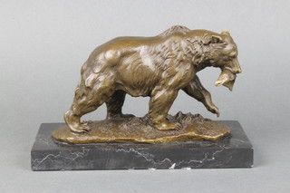A bronze figure of a walking bear with fish in mouth, raised on a black marble base 5" 