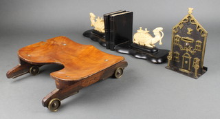 A 19th Century iron and brass money box in the form of a bank 6 1/2" x 4" together with a pair of ebony and ivory bookends in the form of seated camels and  a wooden oarsman rolling seat (slight chip) 