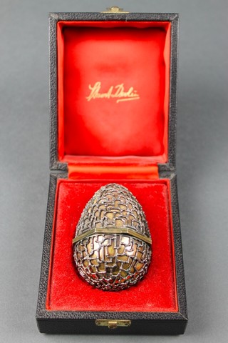 A Stuart Devlin silver gilt "surprise" egg, hinged and opening to reveal an amethyst "floral" display, boxed 