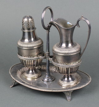 A silver plated stand containing a cream jug and shaker