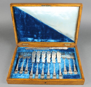 An Edwardian oak canteen containing six pairs of plated secessionist fish eaters and a bread knife