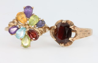 A 9ct yellow gold multi stone dress ring, size N 1/2 and a ditto single stone garnet ring size Q 