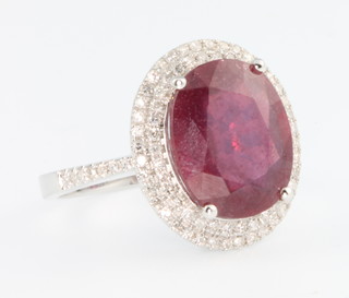 A 14ct white gold ruby and diamond cluster ring, the centre ruby approx. 6.6ct surrounded by brilliant cut diamonds approx. 0.75ct, size M 1/2