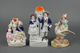 A Victorian Staffordshire spill vase of a shepherd, shepherdess and sheep 9" and two other Staffordshire figures