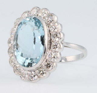 An 18ct white gold aquamarine and diamond oval cluster ring, the centre stone approx 7.5ct surrounded by brilliant cut diamonds approx. 1.5ct size N