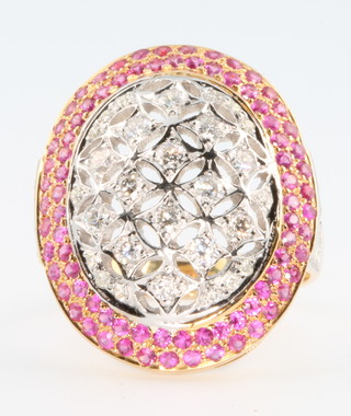 A yellow gold ruby and diamond cocktail ring, the pierced centre panel of diamonds surrounded by 2 tiers of rubies, the shank with diamond set shoulders, rubies approx 0.9ct, diamonds approx 1.27ct, size O, with certificate 