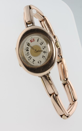 A lady's 9ct rose gold over cased wristwatch with red 12, on a ditto bracelet London 1919