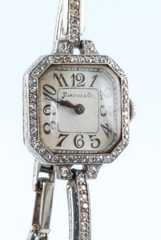A lady's Art Deco platinum and diamond octagonal cased wristwatch on a diamond set bracelet, the dial inscribed Marcus & Co, with diamond winder
