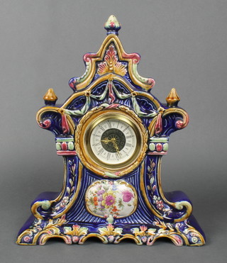 A timepiece with paper dial and Roman numerals contained in a Majolica style pottery case 