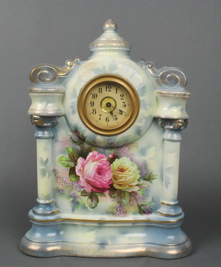 An Edwardian timepiece with paper dial and Arabic numerals contained in a pottery case supported by a pair of columns with floral decoration 