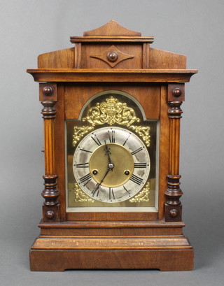 Wurttemberg, a striking mantel clock with arched gilt dial and silvered chapter ring contained in a carved walnut case 