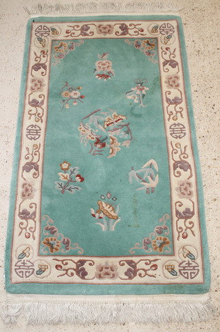 A Chinese green ground rug with floral decoration 63" x 36", some light moth 