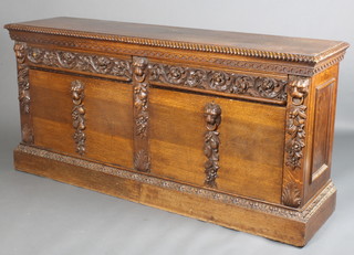 A Victorian carved oak sideboard with gadroon moulding, having 2 drawers and cupboard doors carved with lions masks and fruits and flowers, raised on a plinth base 36"h x 76"w x 19"d 