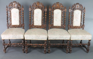 A set of 6 Victorian carved oak Carolean style high back dining chairs, the cresting rails carved shields with upholstered seats and backs 