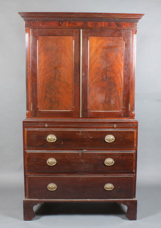 A Georgian mahogany linen press with moulded and dentil cornice and canted corners, fitted 2 trays enclosed by panelled doors, the base fitted a brushing slide above 3 long drawers with brass escutcheon and plate drop handles, raised on bracket feet 77"h x 44"w x 22 1/2"d (made up)
