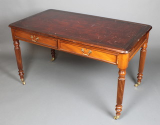 A Georgian style mahogany writing table with inset writing surface above 2 long drawers, raised on turned and reeded supports ending in brass caps and castors 30 1/2"h x 54"w x 30"d 