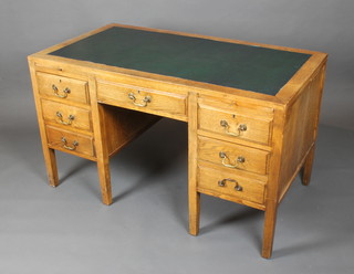 Malcolm Owen, an oak kneehole desk with green writing surface above 1 long drawer, the left hand pedestal fitted a brushing slide and 3 short drawers, the right hand pedestal fitted a brushing slide, 1 short drawer and a file drawer 30"h x 52"w x 28"d (all in one section) 